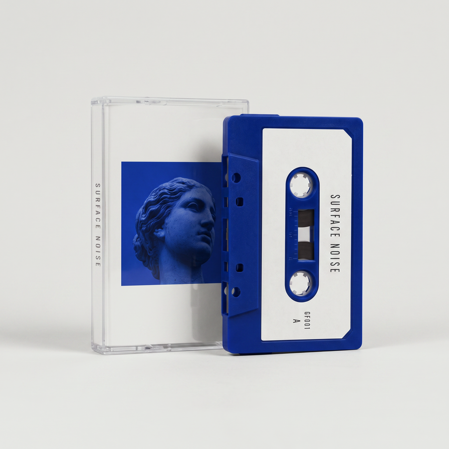 Surface Noise cassette: cobalt shell with an off-white label, clear case with the Venus artwork J-card behind it
